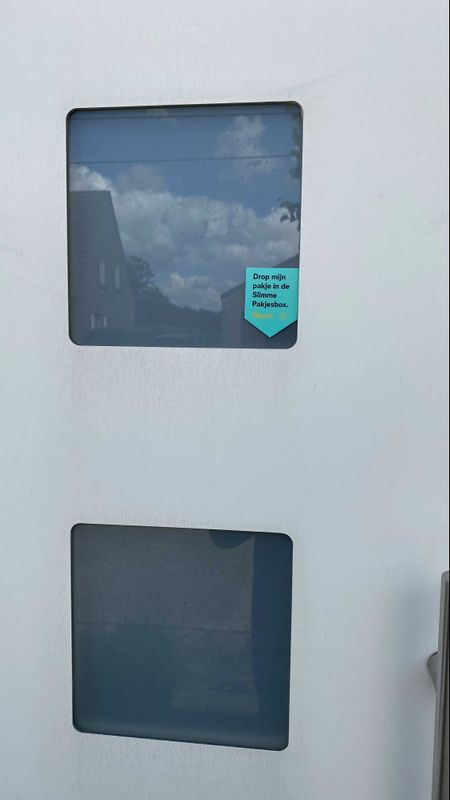 Nogal onopvallende sticker meldt de aanwezigheid van de slimme pakjesbox